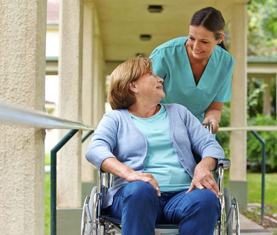 Enfermera con mujer en silla de ruedas